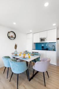a kitchen and dining room with a table and chairs at Blue Breeze Espinho | Pool View, Gym & Balcony in Espinho