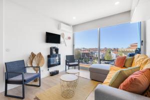 a living room with a couch and a tv at Blue Breeze Espinho | Pool View, Gym & Balcony in Espinho +42 photos