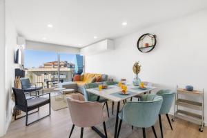 a dining room and living room with a table and chairs at Blue Breeze Espinho | Pool View, Gym & Balcony in Espinho