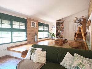a living room with a green couch and a book shelf at La Llar del Magraner in Barraca de Aguas Vivas