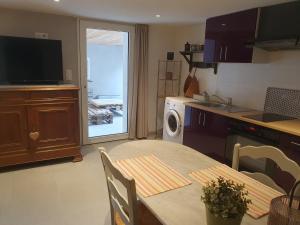 a kitchen with a table with chairs and a kitchen with a sink at La terrasse du romarin in Gorges
