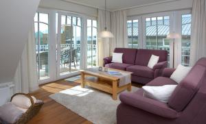 ein Wohnzimmer mit zwei lila Sofas und einem Couchtisch in der Unterkunft Haus EbenEzer in Büsum