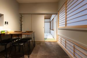 a room with a table and chairs and a bedroom at SYA Hotel-祇園 in Fukuoka