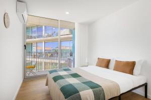 a bedroom with a bed and a balcony at Olivia Maresia Homestay in Espinho
