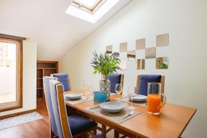 a dining room with a wooden table and blue chairs at Top Floor Retreat in Espinho in Espinho