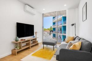 a living room with a couch and a tv at Olivia Maresia Homestay in Espinho