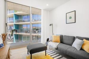 a living room with a couch and a large window at Olivia Maresia Homestay in Espinho +41 photos