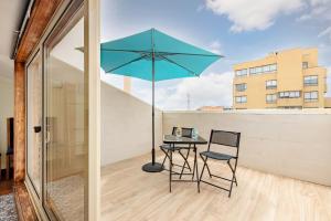 a patio with a table and a blue umbrella at Top Floor Retreat in Espinho in Espinho