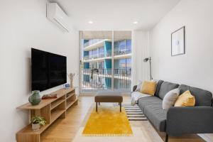 a living room with a couch and a tv at Olivia Maresia Homestay in Espinho