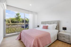 a bedroom with a bed and a large window at Sunny Stays Espinho | Balcony & Pool in Espinho