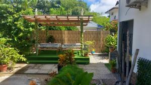 a garden with a bench and a pergola at LA Apartments in Praslin