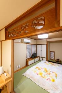 a bedroom with a large bed with flowers on it at SYA Hotel-祇園 in Fukuoka