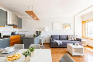 a kitchen and a living room with a couch at Aguda Beach Apartment in Arcozelo