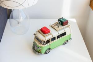 a toy bus with luggage on top of a table at Aguda Beach Apartment in Arcozelo