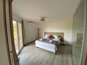 a bedroom with a bed and a glass door at Casa Léna in Propriano +15 photos