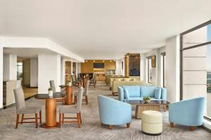 a lobby of a hotel with blue chairs and tables at Sheraton Hanoi Hotel in Hanoi