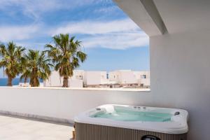 a bathroom with a hot tub on a balcony with palm trees at Las Negras Olivencia Natural in Las Negras