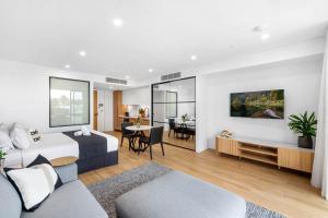a bedroom with a bed and a living room at Kove Apartment - G02 in Kiama