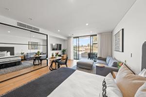a bedroom with a bed and a living room at Kove Apartment - G02 in Kiama