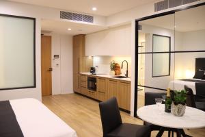 a room with a bed and a table and a kitchen at Kove Apartment - G02 in Kiama +7 photos