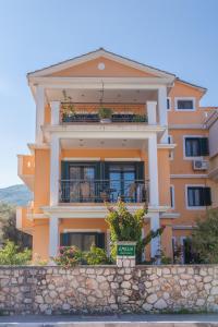 ニドリにあるEmelia Apartmentsの石壁の大きなオレンジ色の家