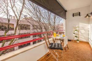 a balcony with a table and chairs and a large window at Cantinho em Cascais, Spacious 3BR with Balconies in Cascais