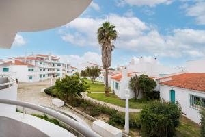 a view from the balcony of a house with a palm tree at Prainha Family Fun | Balcony & Pools in Alvor +39 photos