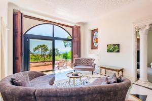 a living room with a couch and a large window at Estoril Royal Atlantic Villa with Ocean View in Estoril