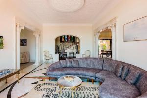 a living room with a large blue couch at Estoril Royal Atlantic Villa with Ocean View in Estoril +72 photos