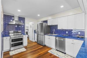 a large kitchen with white cabinets and blue tiles at 2812 Tulane Dr in Cocoa