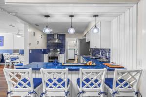 a kitchen with a blue counter and three chairs at 2812 Tulane Dr in Cocoa +52 photos