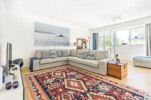 a living room with a couch and a rug at Luxury Beach Experience in Lisbon in Oeiras +44 photos