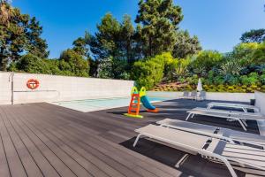 a deck with lounge chairs and a swimming pool at Luxury Beach Experience in Lisbon in Oeiras