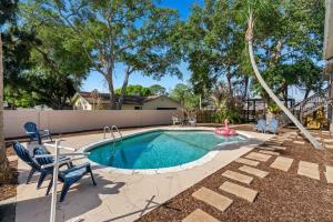 a swimming pool with chairs and a toy in a yard at 1055 Shady Lane in Merritt Island