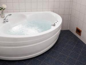 a bath tub filled with blue water in a bathroom at 6 person holiday home in Leikanger in Leikanger +17 photos