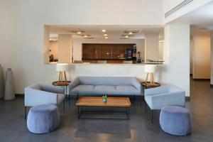 a living room with blue couches and a table andools at City Express by Marriott Mexicali in Mexicali