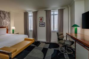 a hotel room with a bed and a desk and a chair at Le Meridien Indianapolis in Indianapolis