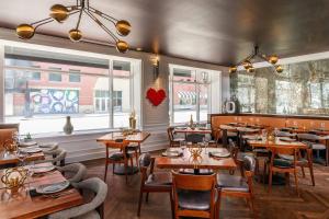 a restaurant with wooden tables and chairs and windows at Le Meridien Indianapolis in Indianapolis