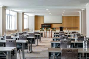 an empty room with tables and chairs and a chalkboard at Le Meridien Indianapolis in Indianapolis