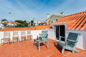 a patio with chairs and a table on a roof at Casalinho de Bicesse in Alcabideche