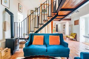 a blue couch in a living room with a staircase at Casalinho de Bicesse in Alcabideche