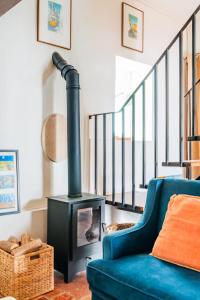 a living room with a blue couch and a wood stove at Casalinho de Bicesse in Alcabideche