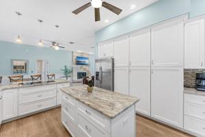 a kitchen with white cabinets and a refrigerator at 5665 S. Tropical Trail in Merritt Island