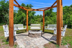 three white benches sitting around a fire pit at 5665 S. Tropical Trail in Merritt Island