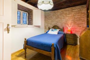 a bedroom with a bed and a brick wall at Casa Mont'Santo with Balcony & Terrace in Monsanto