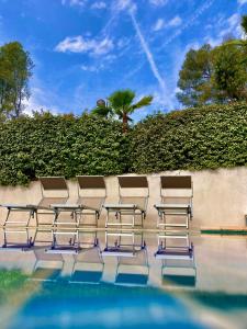 a row of chairs sitting next to a swimming pool at Sélection Camping La Croix -Valmer in La Croix-Valmer