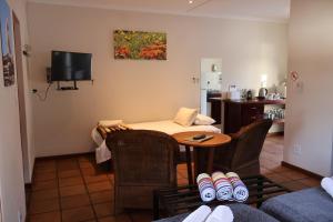 a living room with a table and chairs and a tv at Aant Dorpseind in Vanrhynsdorp