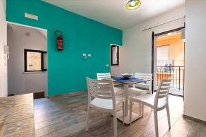 a dining room with a blue wall and a table and chairs at Perla Marina Rooms in Realmonte +62 photos