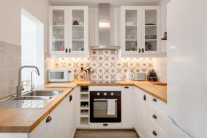 a kitchen with white cabinets and a sink at Pinhal da Praia em Melides in Quinta da Cascalheirinha