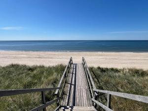 a wooden boardwalk leading to the beach at Haus Elvi Fuchs an den alten Salzwiesen in Westerland